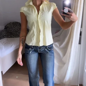 Gul blus från Moments - Säljer en söt vintage gul blus med korta ärmar och knappar framtill. Är i storlek M men passar mig som vanligtvis är storlek XS/S. Blusen har en fin passform med rynkade detaljer vid axlarna. Perfekt för en solig dag och nu till sommaren💗
