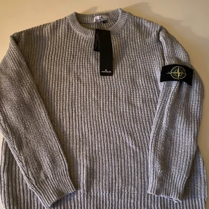 Stickad Stone Island tröja - Tröjan är storlek M, tröjan sitter dock SOM STORLEK S. kan gärna skick mått på hur lång och bred tröjan är ifall du är osäker. Tröjan är aldirg andvänd så alltså i helt nytt skick.