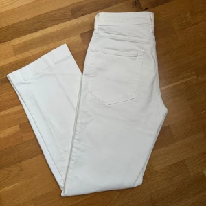 Vita byxor från Zara - Snygga vita byxor från Zara i en klassisk design. Byxorna har en rak passform och är tillverkade i ett mjukt material. Perfekta för en stilren look.