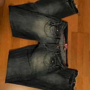 Blå jeans med bootcut - Säljer ett par blå jeans med bootcut och slitna detaljer. Jeansen har en klassisk femficksdesign och en läderpatch på baksidan. Perfekta för en avslappnad stil. Ungefära mått: innerbens längd 80cm, midja 39cm men stretchiga. Har inga fler bilder ❤️ kom med pris förslag 