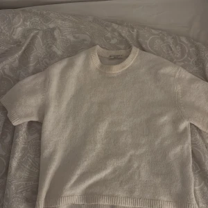 Vit stickad tröja från Gina Tricot - Säljer en vit stickad tröja från Gina Tricot i storlek M. Tröjan har en rund halsringning och korta ärmar, perfekt för lager-på-lager eller som den är. Enkel och stilren design som passar till många olika outfits. Bara använd en gång för att de är inte min stil💕