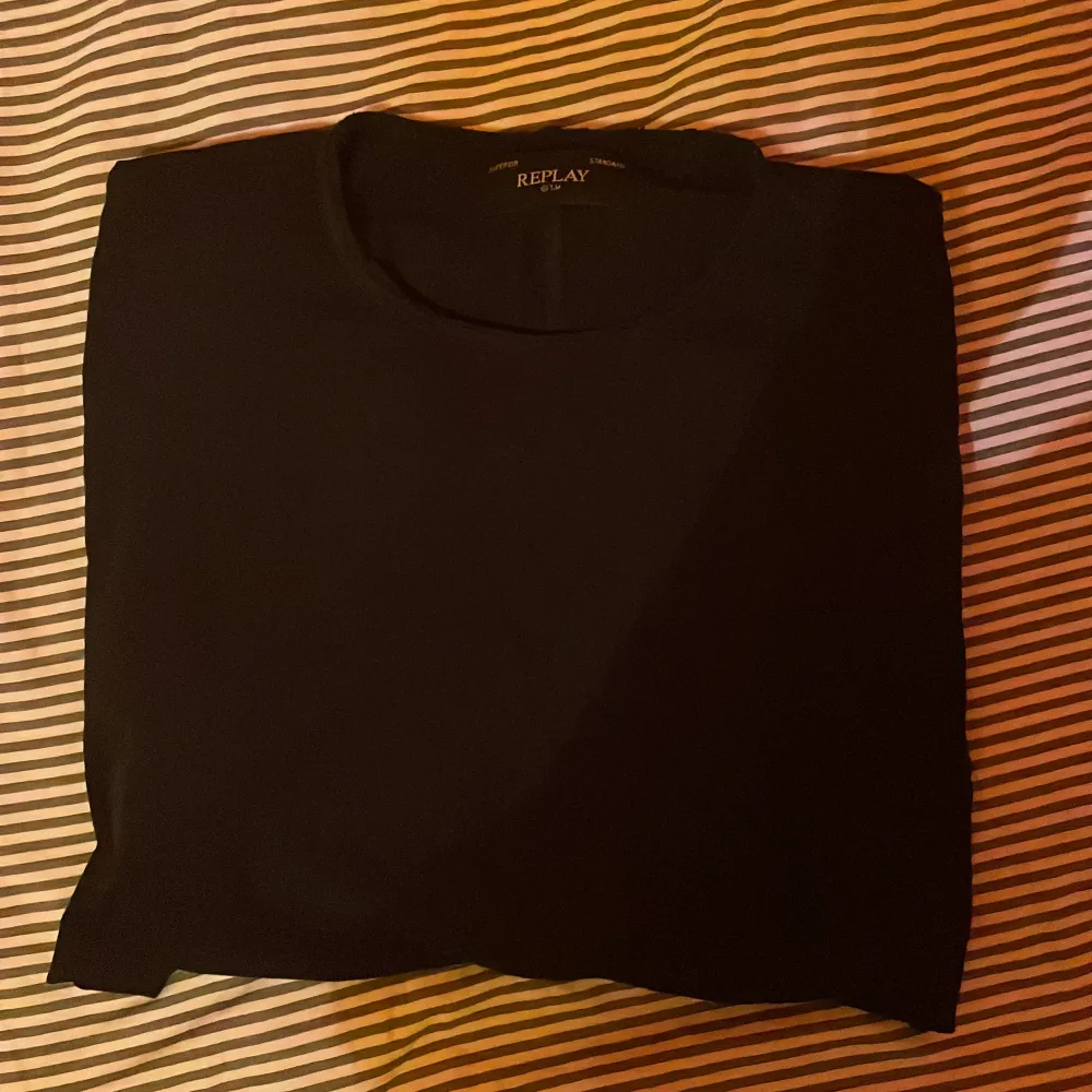 Säljer en stilren svart t-shirt från Replay. Den har en klassisk design med korta ärmar och rund hals. Perfekt för en enkel och snygg look.. T-paidat.