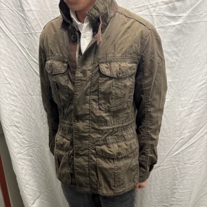 Brun jacka från Tommy Hilfiger S - Säljer en brunjacka från Tommy Hilfiger med flera fickor och knappar. Jackan har en stilren design med dragkedja och knappstängning. Perfekt för en casual look. Bra skick, inga defekter. Storlek S. Modellen är 182cm/67kg