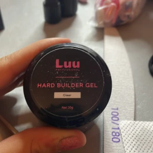 Luu Professional Hard Builder Gel - Luu Professional Hard Builder Gel i en klar nyans, perfekt för att bygga starka och hållbara naglar. Burken innehåller 30g av gelén som är idealisk för professionell användning eller hemmabruk. Den är lite smutsig men det syns knappt vid användning.