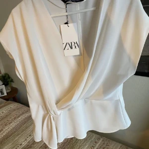 Vit omlottopp från Zara - Jätte fin topp från Zara, nästan aldrig använd och därför som ny💞