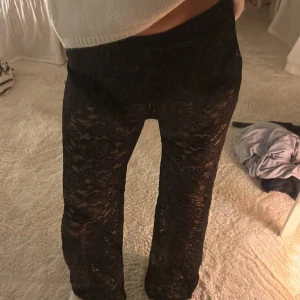 Svarta spetsbyxor - Snygga svarta byxor i spetsmaterial med ett blommigt mönster. Byxorna har en loose passform och är perfekta för en trendig look. Jättefina att ha till utekvällar i vår/sommar!💕⚡️är 173 cm lång och de går hela vägen ner! Ganska stretchiga i midjan, jag har vanligtvis midjemåttet 74cm så de går både över och under det! 