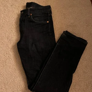 Mörkblå jeans från Levi's premium 501 - Snygga mörkblå jeans från Levi's med klassisk femficksdesign och knappgylf. Perfekta för en stilren look. Levi's-logga på baksidan och kontrastsömmar som ger en cool touch.