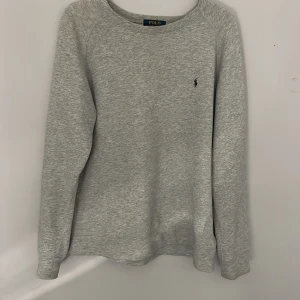 Grå tröja från Polo Ralph Lauren - Säljer en stilren grå tröja från Polo Ralph Lauren med 7/1o skick. Den är inte så tjock så den är Perfekt nu till våren eller som våren. Från 14-16år så alltså L i barns storlek 