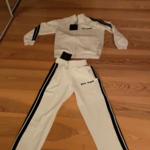 palm angles  - Snygg vit palm angels sett. de är nytt men säljer de då de va för stort för mig. de är storlek 24 i byxorna och i tröjan är de 5 står de. de är ett jätte skönt sett som man till och med kan träna i om man vill. 1500 för byxorna och 1500 tröjan och båda för 2500