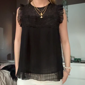 Svart ärmlös blus med spetsdetaljer - jätte bra skick snygg svart blus t middag eller fest 