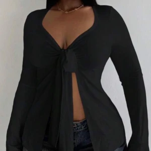 Svart långärmad knytblus - Snygg svart långärmad blus med knytning framtill. Aldrig använt 