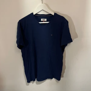 Mörkblå t-shirt från Tommy Hilfiger - Säljer en stilren mörkblå t-shirt från Tommy Hilfiger. Den har en liten logga på bröstet och är tillverkad i mjukt material. Perfekt för en avslappnad look.