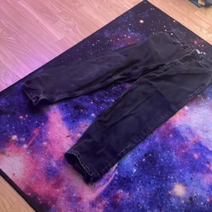 Svarta jeansbyxor - Snygga svarta jeansbyxor med klassisk femficksdesign. Byxorna har en rak passform och är perfekta för en stilren look. De är tillverkade i ett slitstarkt material som ger en bekväm känsla hela dagen. Från lager 157. W27L32