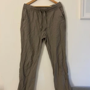 gröna linnebyxor  - Säljer ett par bekväma gröna linnebyxor med elastisk midja och snörning. Perfekta för en avslappnad stil. Byxorna har en loose passform och är tillverkade i ett mjukt material.