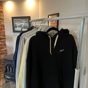 Svart hoodie från Arigato - Säljer en stilren svart hoodie från Arigato med vit broderad text på bröstet. Gul/vit fadeade snören till luvan. Mycket bra skick då jag aldrig använder hoodies. Köpt för 2300 på NK.