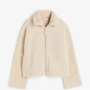 Beige teddyjacka med dragkedja - Mysig beige teddyjacka med dragkedja framtill. Jackan har en hög krage och långa ärmar