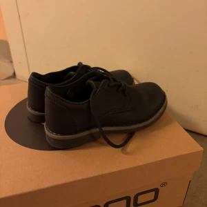 Svarta skor från Zack - Snygga svarta skor från Zack med rund tå och snörning. Perfekta för en stilren look. Skorna har en robust sula och är tillverkade i skinn för en klassisk känsla.