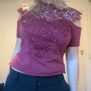 Vinröd topp med spets - Fin vinröd topp med spets, den är klippt både nertill och vid armarna men inget som syns tydligt. 