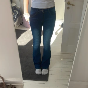 Blå bootcut jeans - Snygga blå bootcut jeans som är extra sköna och mjuka! Har aldrig använt dom! Vid låren så är dom lite tajtare men sedan viker ut sig där nere vid underbenen!