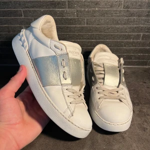 Valentino Garavani sneakers vit/silver - Snygga Valentino Garavani sneakers i vitt skinn. Storlek 36 sitter 36-37. I bra skick 7/10 inga hål eller liknade enbart spår av normal användning. Hör av er vid frågor 