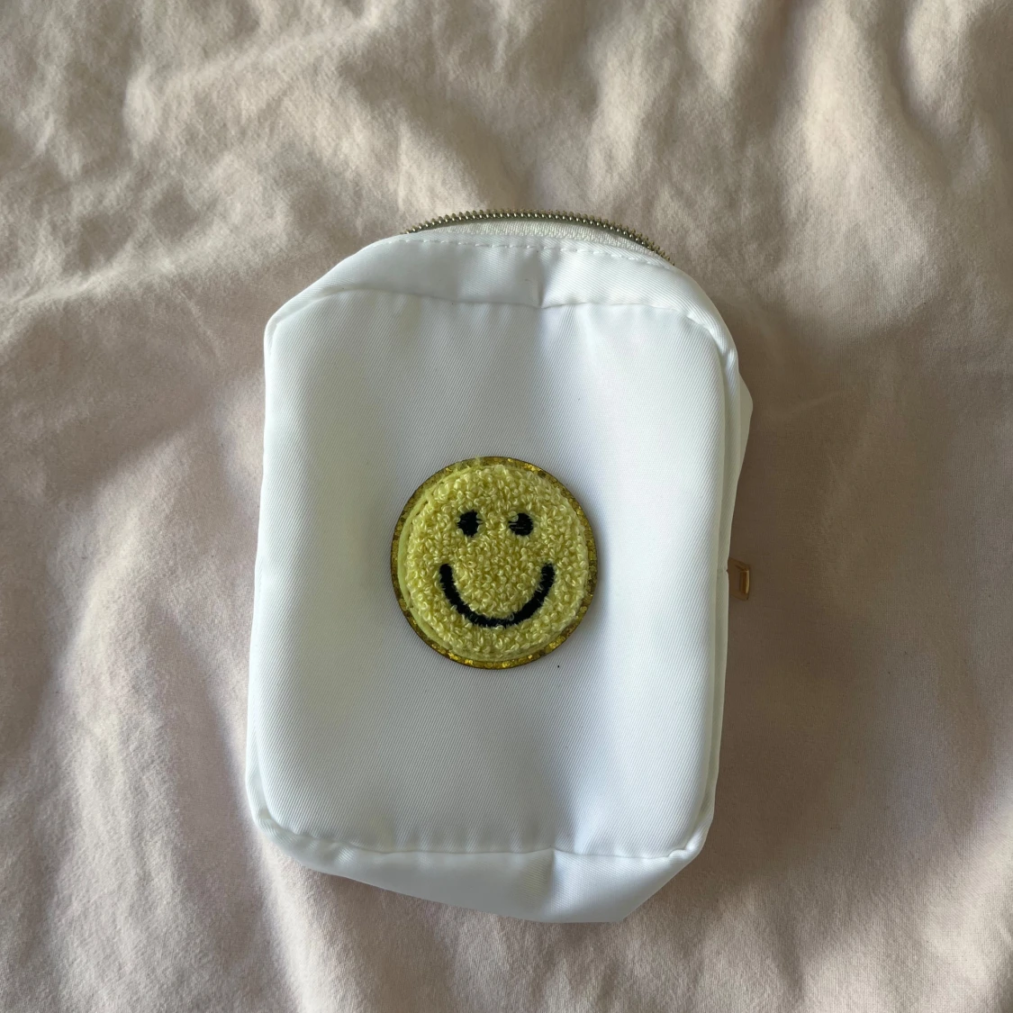 Vit liten väska med smiley-detalj
