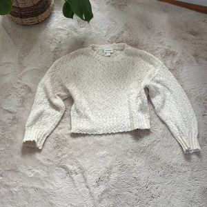 Vit stickad tröja från Monki - Supermysig vit stickad tröja från Monki i storlek S. Tröjan har en croppad passform, rund halsringning och långa ärmar med ribbade muddar. 