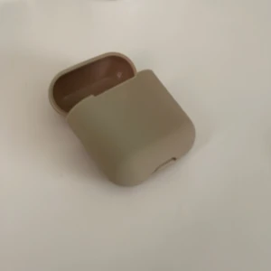 Beige fodral för hörlurar  - Aldrig använt. Beige fodral för AirPods