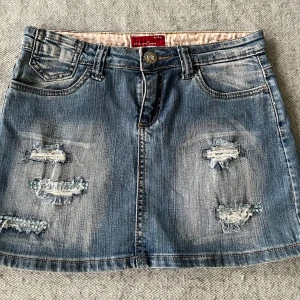 Jeanskjol - Superfin jeanskjol i storlek 34/36. Mått kan fås om önskas. Endast några stenar som har fallit av, men jag kan skicka med några vita om man vill som enkelt kan limmas fast med textil lim🌟🩷