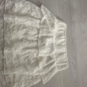 Vit kortkjol med  blommor från Vero Moda - Supersöt vit kortkjol från Vero Moda med broderade små blommor och bred smock i midjan.  🌸Säljer då jag ej använder den längre 