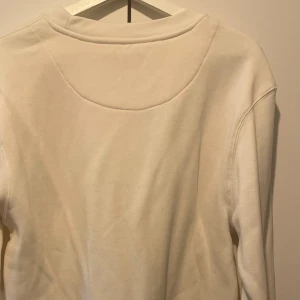 Beige/kräm vit sweatshirt från Primark - En stilren beige/kräm vit sweatshirt från Primark i storlek medium. Tröjan har rund halsringning, långa ärmar och är tillverkad i mjuk bomull. Perfekt för en chill och avslappnad look.