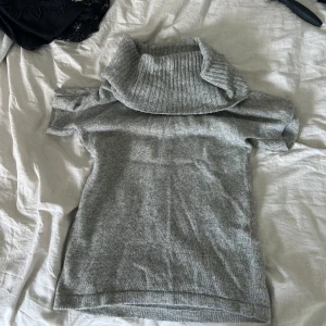 Grå stickad polotröja med kort ärm - Snygg grå stickad polotröja med korta ärmar och bred, ribbad polokrage. 