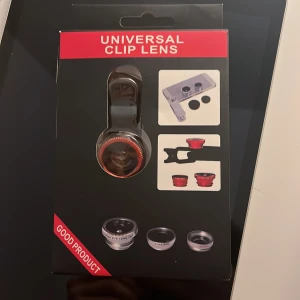 Fish eye lens - Bilderna visar en förpackning med en universal clip-lins för mobiltelefoner, inklusive fisheye-, makro- och vidvinkellins. Perfekt för dig som vill ta kreativa och unika bilder direkt med mobilen. Lätt att använda och passar de flesta smartphones. Gör dina foton mer spännande och dela dem med vänner!