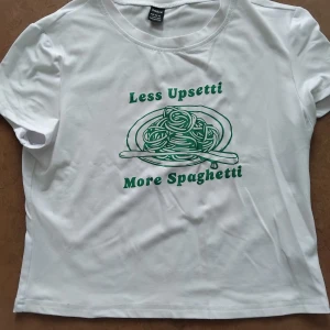 Tshirt med tryck - Vit tshirt med grönt tryck; Less Upsetti, More Spaghetti. Storlek L men är en baby tee, så sitter tight även på M. Från Shein. Fint skick, endast använd och tvättad någon enstaka gång. 