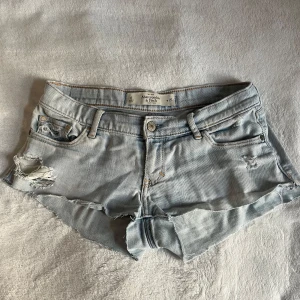 Ljusblå Lågmidjade jeansshorts  - Snygga ljusblå jeansshorts från Abercrombie & Fitch med slitna detaljer och fransig kant. 