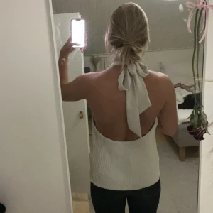 vit plisserad halterneck topp - säljer en vit plisserad topp med halterneck och snygg knytning i nacken, perfekt för varma dagar eller när du vill sticka ut lite extra! 