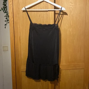 Svart linne med spets och snörning - Supersöt svart linne med smyckes detaljer. Kommer inte till användning men super fin och unik! 