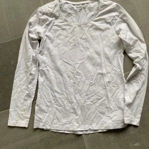Vit långärmad tröja från Basic - En enkel och stilren vit långärmad tröja från Basic. Tröjan har rund halsringning och är tillverkad i ett mjukt bomullsmaterial. Perfekt att ha som basplagg i garderoben.