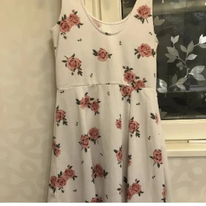 Blommig klänning - En fin vit sommarklänning med Rosor på, endast använd 1 gång💕perfekt till varma sommardagar eller till skolavslutning!🤍🤎