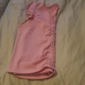 Gullig Rosa topp med volangärmar - Söt rosa topp med korta volangärmar och rund halsringning. Perfekt för vår och sommar, enkel att matcha till olika outfits. Storlek 170 men är liten i storleken!