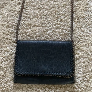 Svart axelväska med kedjerem - jag säljer en väska som inte är så använd💕 tappat lite färg på kedjan men ändå fin🩷