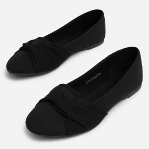 Svarta ballerinaskor med knutdetalj - Säljer ett par stilrena svarta ballerinaskor med snygg knutdetalj framtill. Skorna har rund tå och platt sula, perfekta för en enkel och klassisk look. Passar till många olika outfits och är lätta att matcha.