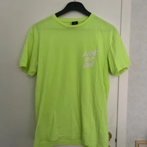 Neongrön t-shirt  - Herr t-shirt med motiv ’Live or die’. Fint skick förutom skrynklig. Oversized fit. Axelbredd 50cm, längd 71cm.