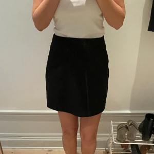 Svart kortkjol - Enkel svart kortkjol med rak passform. Kjolen är stilren och passar perfekt till många olika outfits. Säljer pga för stor för mig. Aldrig använd 