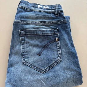 Blå jeans från Dondup - Säljer ett par klassiska blå jeans från Dondup, tillverkade i Italien. Jeansen har fem fickor, raka ben och en snygg tvätt med lätt slitning. Modell: GEORGE