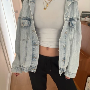 Ljusblå oversized jeansjacka - Säljer en ljusblå jeansjacka i oversized modell. Jackan har klassiska bröstfickor med knappar och silverfärgade detaljer. Perfekt att slänga över en t-shirt eller hoodie för en avslappnad look.