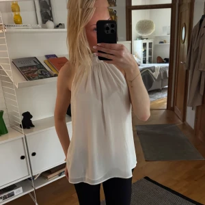 Vit ärmlös blus med hög hals - Säljer en stilren vit blus med hög hals, sjukt fin till sommaren!! ❤️