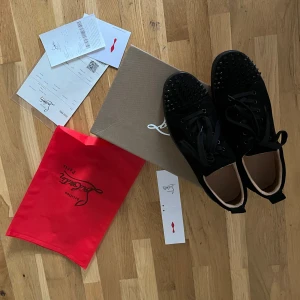 Svarta sneakers med nitar från Christian Louboutin - Säljer ett par svarta sneakers från Christian Louboutin med svarta nitar. Kommer med originalkartong och röd dustbag.