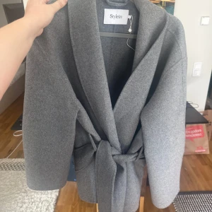 Stylein kappa - Grå omlottkappa från stylein. Nypris 5 499kr. Använd få gånger, som ny. Sitter som en M-L. Pris är diskuterbart.