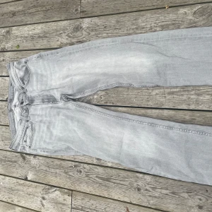 Ljusgrå jeansbyxor från Dressmann - Säljer ett par ljusgrå jeansbyxor från Dressmann med straight passform. Klassisk femficksmodell med dragkedja och knapp i midjan. Perfekta för dig som gillar en enkel och stilren look. Hör av dig för frågar 😋