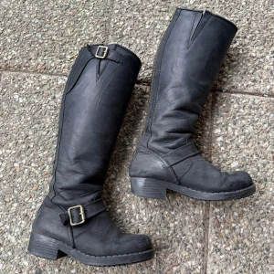 Svarta höga boots med spänne - Säljer ett par svarta höga boots i skinn. Boots  har två metallspännen och dragkedja på insidan. Johnny Bulls är märket och köpt dyrt några år sedan. Perfect ”vintage” slitna <3 